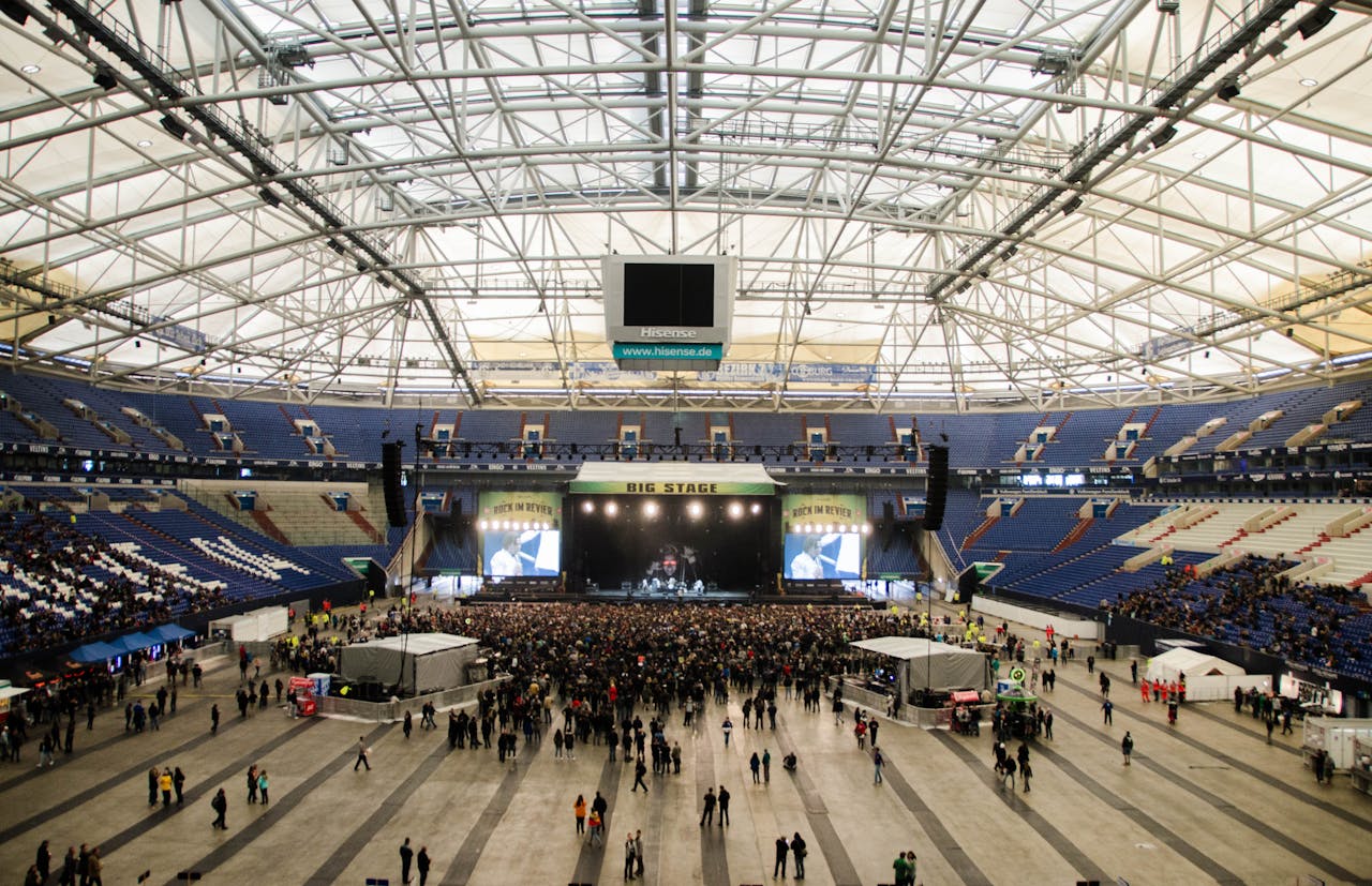 services-03 Wide shot of a crowded concert in a large indoor arena with a prominent stage.